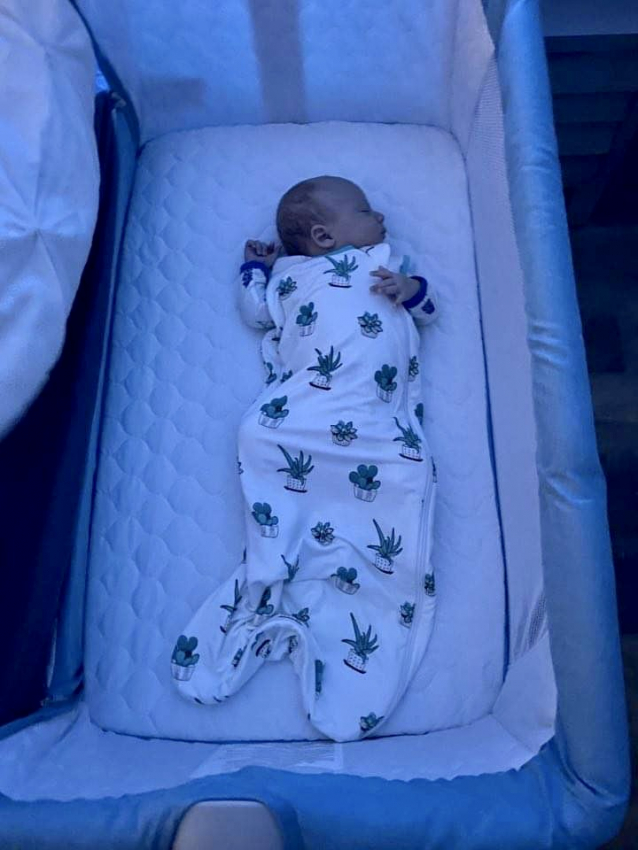 Toddler in a white sleep sack.