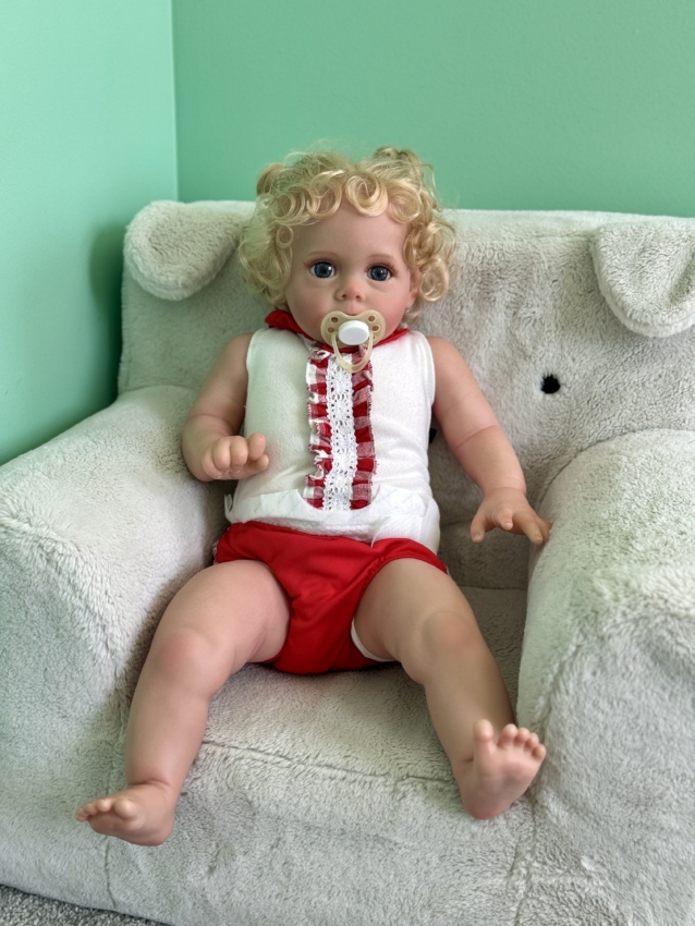 realistic baby doll sitting on a toddler chair