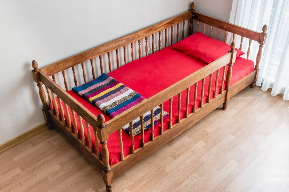 Close to ground montessori floor bed with red mattress.