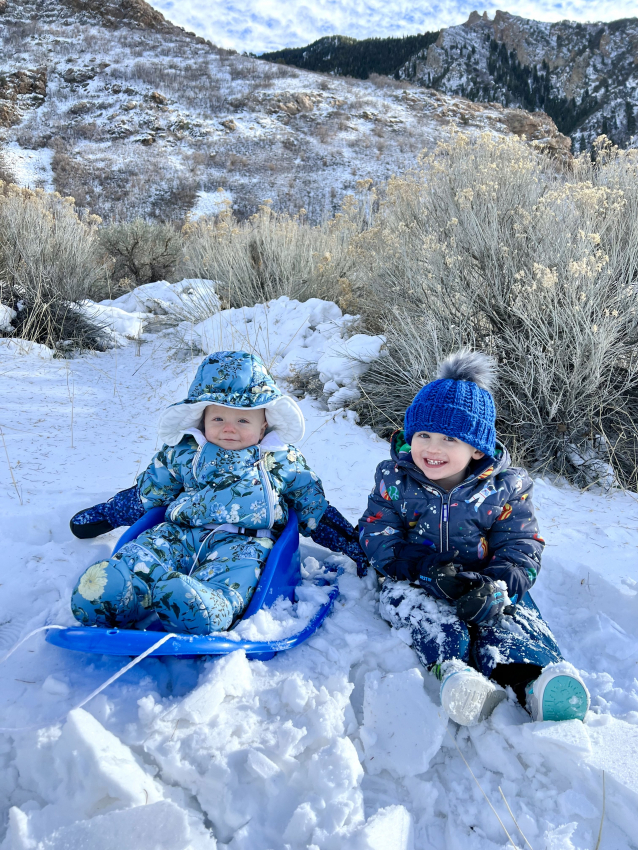 1 year old sledding with siblings