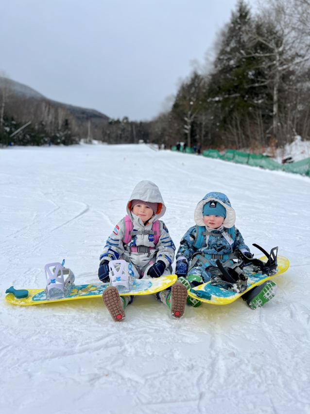 Toddlers snowboarding