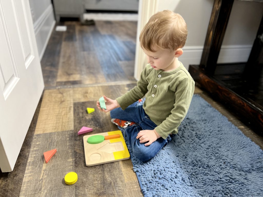 Toddler playing with wooden puzzles