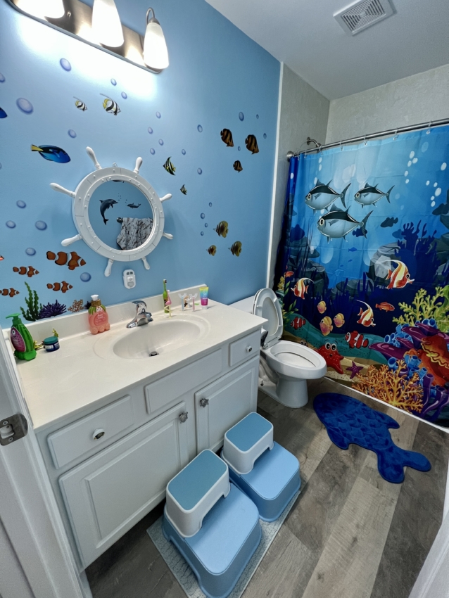 Blue step stools for toddlers in front of a wash basin.