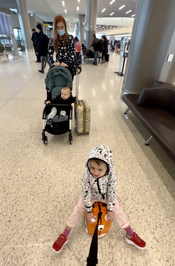 3 year old riding trunki suitcase at the airport