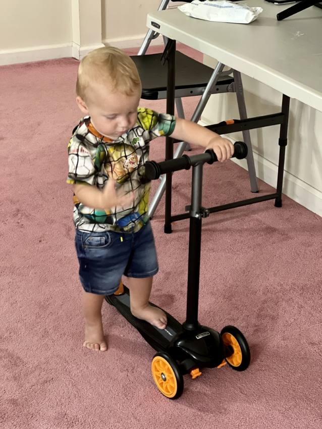 Toddler on a scooter with 3 wheels