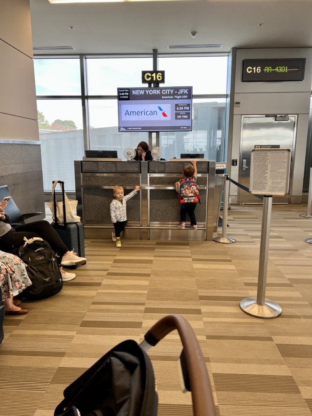Two toddlers at the airport waiting for a flight
